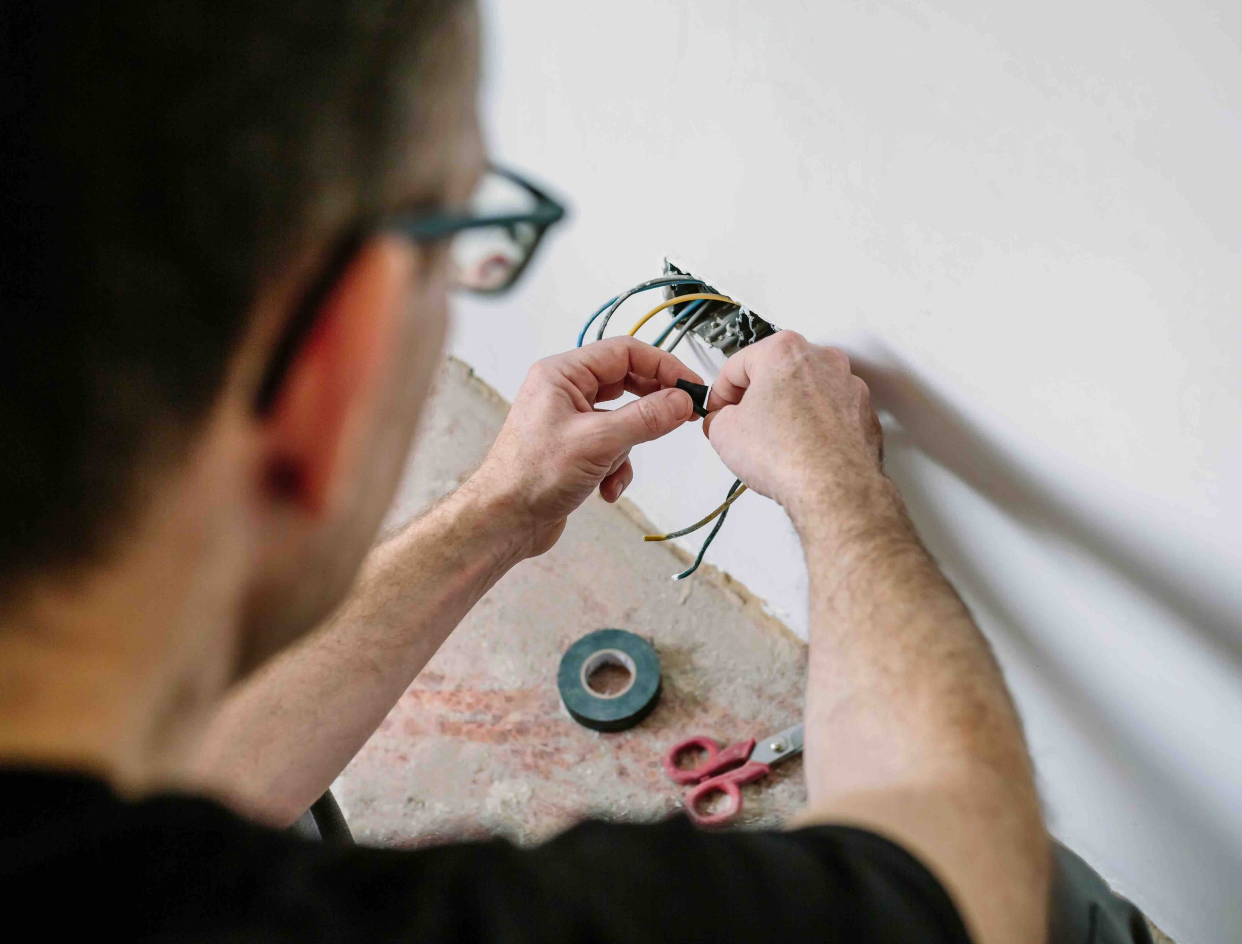 Photo of an electrician replacing wiring.