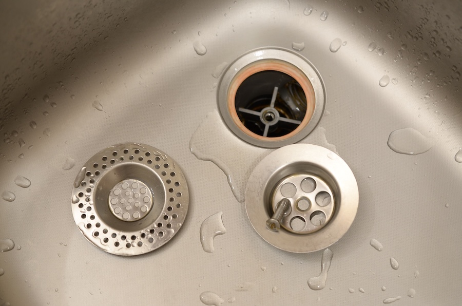 A photo of a stainless steel drain in the middle of the repair and replacement process.
